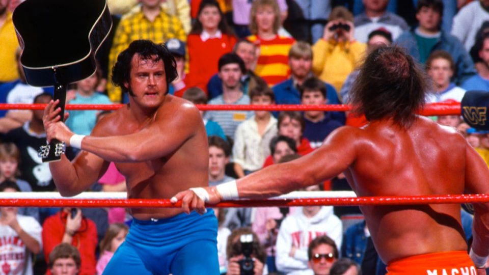 The Honky Tonk Man threatens Randy Savage with a guitar